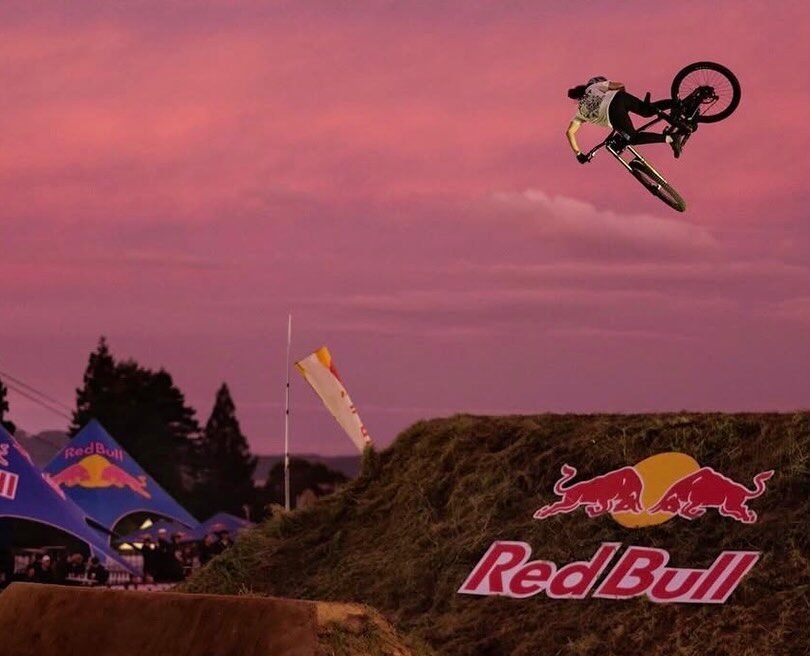 Indy Deavoll airborne at a Red Bull mountain bike event at sunset